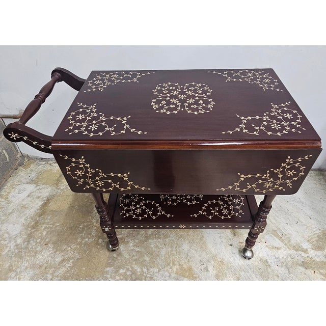 A South East Asian Hancrafted Bone Inlay Rosewood Drop Leaf two tier rolling Serving Trolley Measures 33" in width, 18.5"...