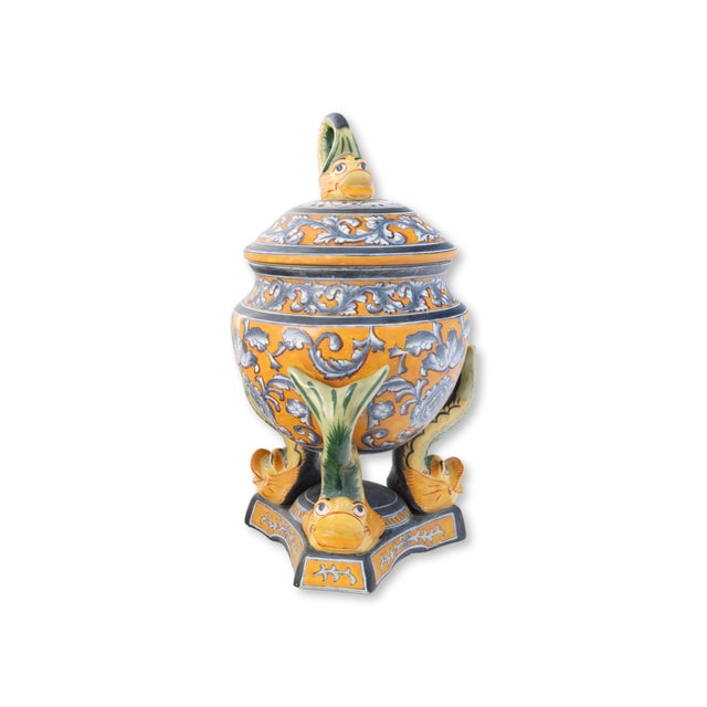 Large scale vintage faience urn decorated in vibrant yellow, blue, and green glazes with scrolling foliate motifs and...
