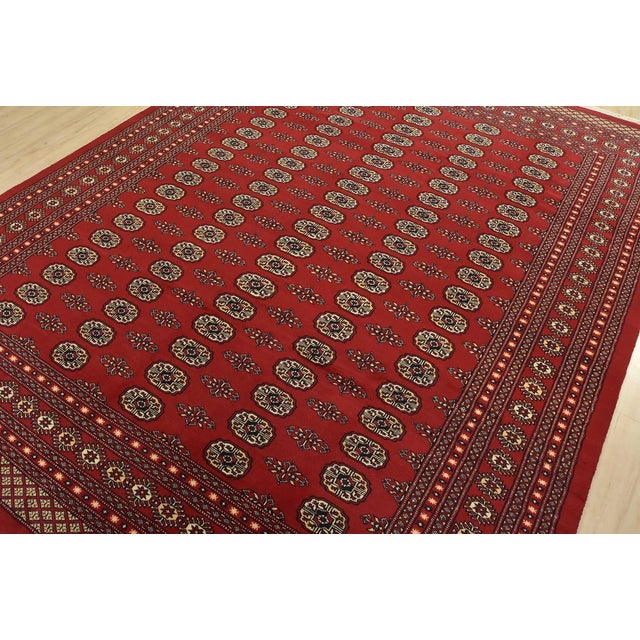 A tribal Bokhara rug hand-knotted with fine wool on a cotton foundation. This rug features rows of repeating medallions...