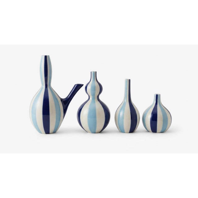 A striking set of four Jonathan Adler ceramic vessels in a coordinated palette of navy blue, light blue, and white...