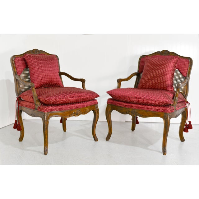 This is an elegant pair of Vintage French Bergère Carved Wood and Cane Occasional Chairs. Expertly crafted, the chairs are...