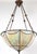 Arts & Crafts style bowl pendant light featuring iridescent slag glass panels joined together by lead to create a...