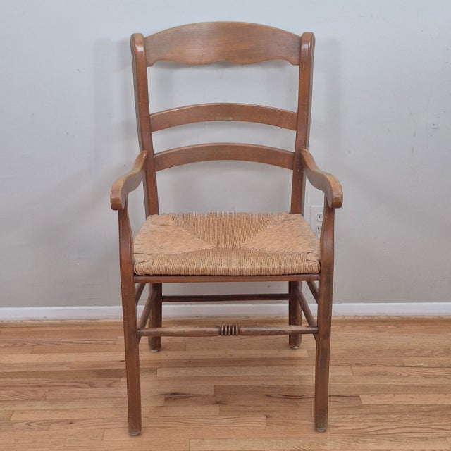 This is a vintage French country style arm chair with solid wood construction, shaped ladder back, scrolled arms, woven...