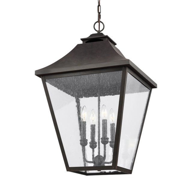 The Sean Lavin Galena four light outdoor pendant fixture in sable creates a warm and inviting welcome presentation for...
