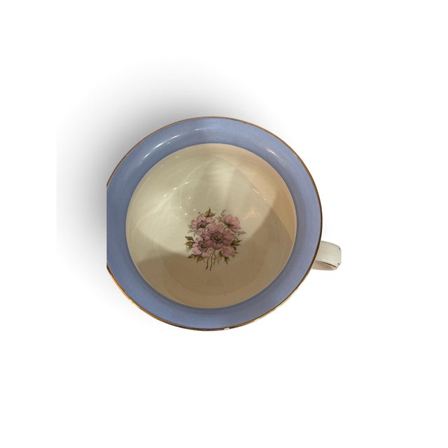 Charming vintage porcelain chamber pot featuring a romantic pink floral motif against a warm ivory ground. A soft powder-...