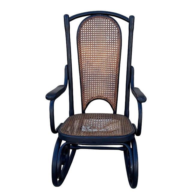 Vienna Secession style rocking chair featuring an elegant, sculptural frame crafted from warm-toned bentwood with striking...