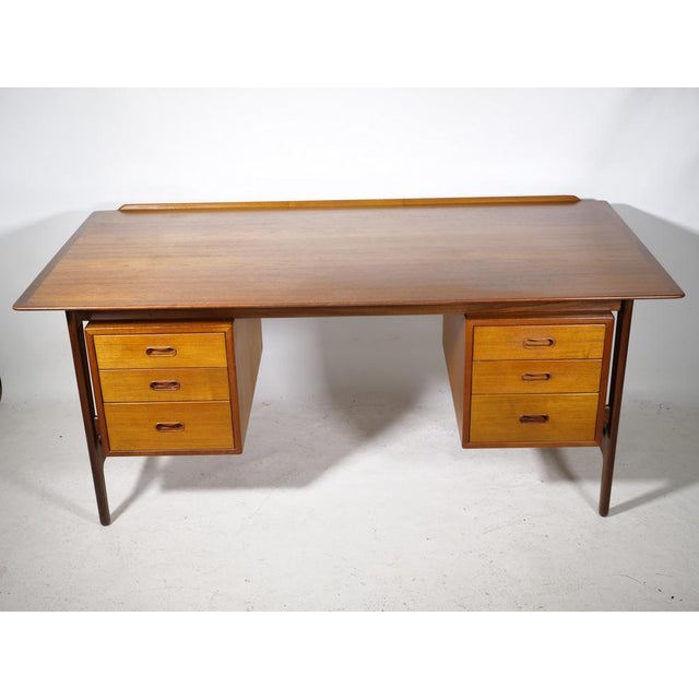Experience timeless elegance and functionality with this impressive Danish mid-century desk made of teak, designed by the...