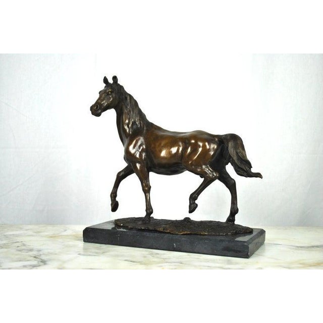 A 20th century bronze horse on a marble base. A very well cast and chased trotting horse, upon the cast bronze turf...