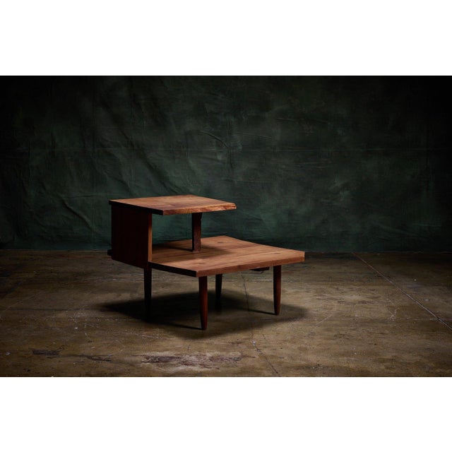 George Nakashima American black walnut tiered corner table with two levels, crafted from solid American black walnut wood....