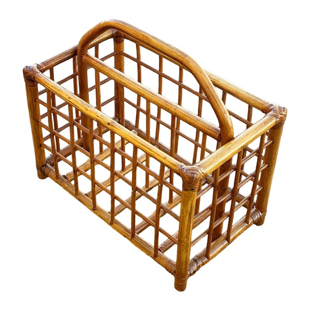 This beautifully restored Mid-century rattan magazine rack featuring a carrying handle featuring an geometric open-grid...