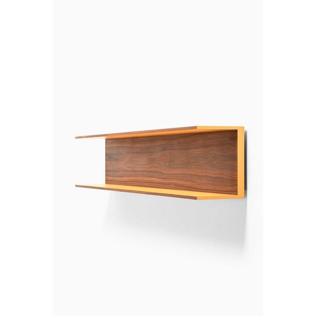 This rare wall shelf, designed by walter wirz and produced by wilhelm renz in germany, exemplifies the restrained elegance...