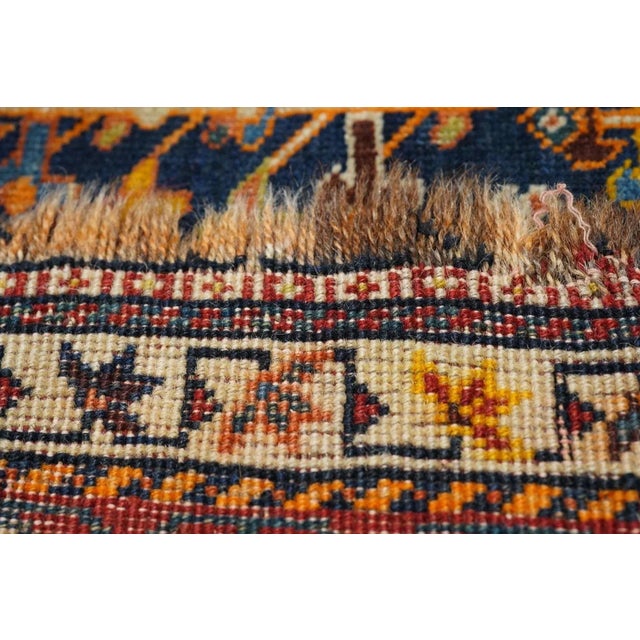 The dark blue subfield shows a zig-zag edge and an allover, unidirectional display of animals and stylized flowers, all...