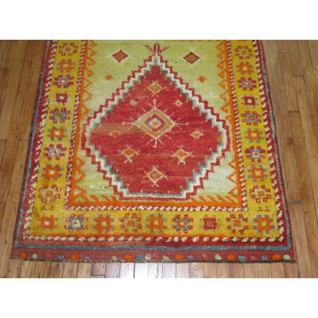 A Turkish Tulu prayer rug with saturated colors in predominant red. Lime green and orange tones Measures: 4' x 4'9".