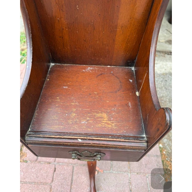 This antique candle table features a classic Queen Anne-style design with a rich, dark wood finish. The piece includes a...