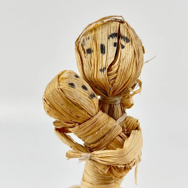 This Handmade corn husk mother and child from Zimbabwe depicts a working mother carrying her child and a load of wood....