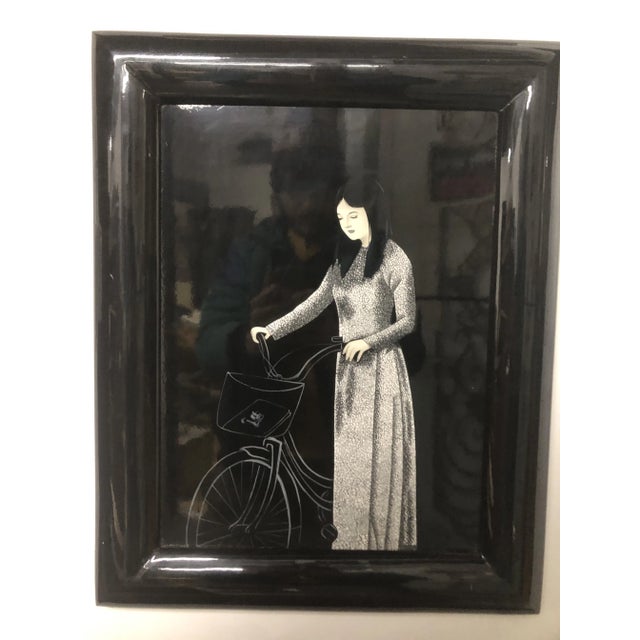 Beautiful Vietnamese lacquered egg shell art of girl with bike. Displayed in black lacquered frame with attached hanging...