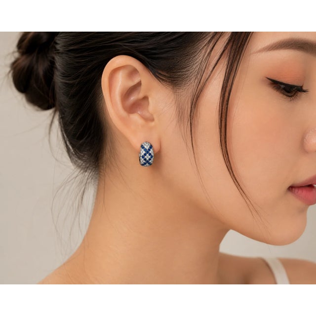 These 14K White Gold Huggie Earrings feature natural round sapphires totaling 1.00 carat, accented by brilliant round...