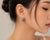 These 14K White Gold Huggie Earrings feature natural round sapphires totaling 1.00 carat, accented by brilliant round...