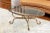 This highly refined patinated gilt, wrought iron cocktail table takes form with four scrolled upswept legs joined with...