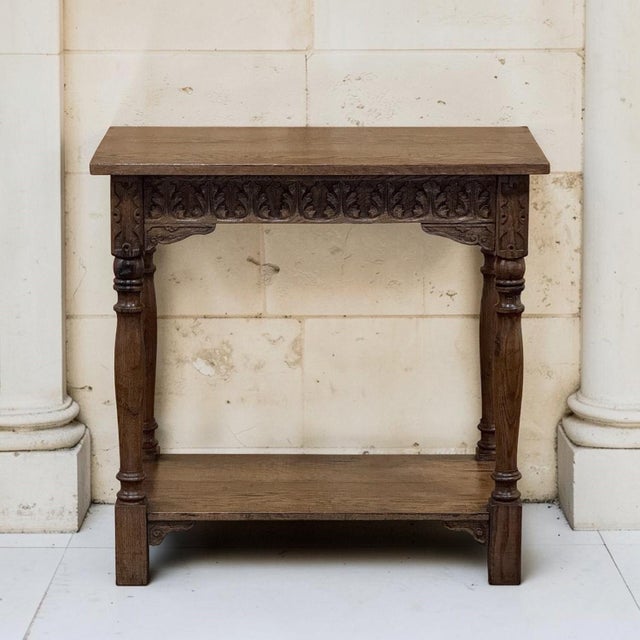 A 19th century rustic oak side table, hand carved with a frieze of acanthus leaves running across the apron beneath a...