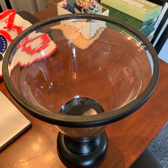 Beautiful, modern glass hurricane candle holder with a sleek matte black pedestal base. Features an elegant flared trumpet...