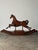 Carved from solid pine with a flowing, sculptural silhouette, this vintage rocking horse plants its front legs mid-stride...