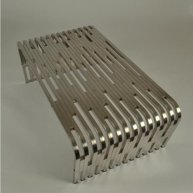 Large sculptural stainless steel coffee table is made out of extruded boxed stainless steel segments. The steel is crafted...