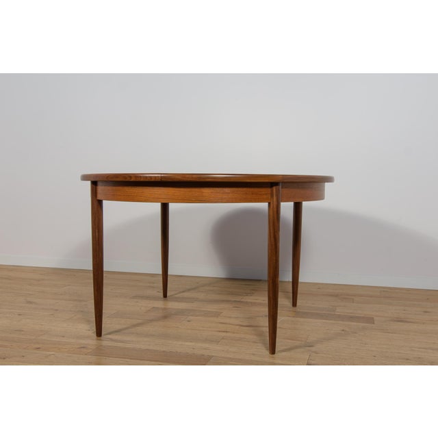 This round extendable dining table was produced by G-Plan in the 1960s. The table has profiled reinforced edges of the...