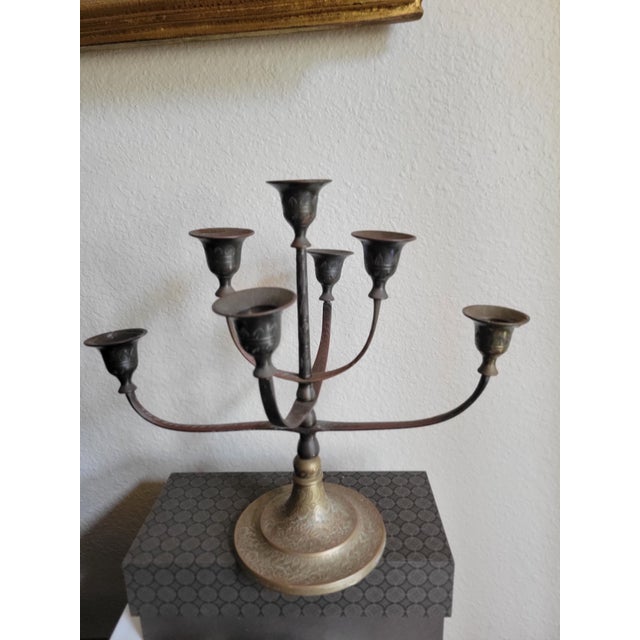A sculptural vintage brass candle holder featuring six gracefully adjustable curved arms, each ending in a flared,...