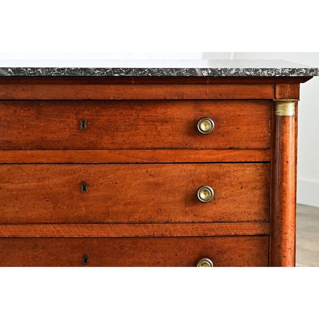 A robust French Empire walnut commode from the 19th century, topped with an incredible slab of Saint Anne marble. The dark...