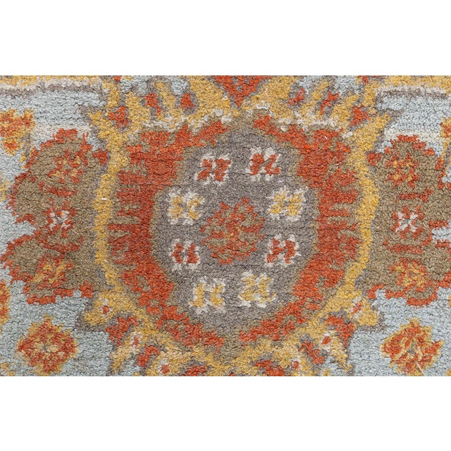 This elegant early 20th-century English Axminster rug is a masterful example of period craftsmanship, echoing the romantic...