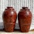 A fabulous pair of vintage Boho urns. Chic hand painted finish in a warm brownish rust color. Perfect indoors or outside...