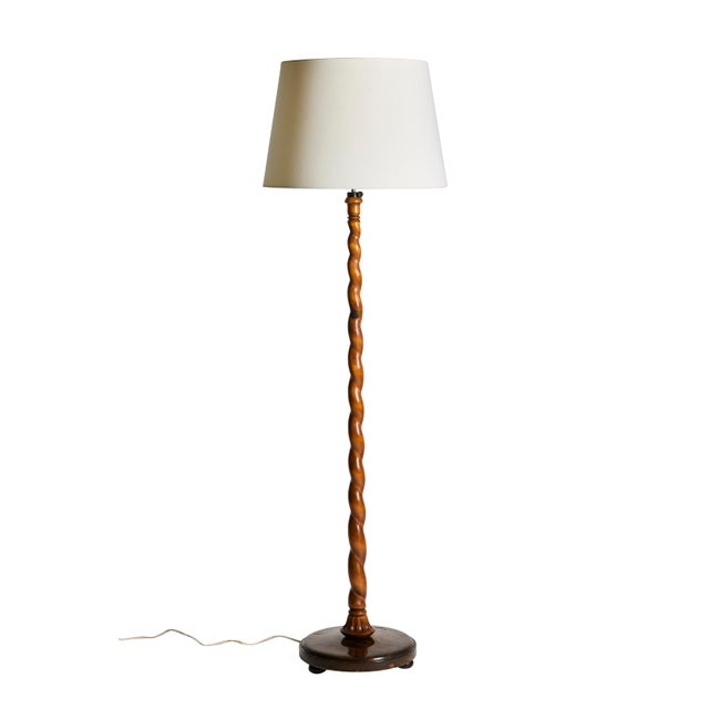 Swedish Grace floor lamp in carved wood, Sweden, circa 1930s-40s. The lamp features a dramatic hand-carved barley twist...