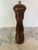 A mid-century wooden Peugeot pepper mill with a gently curved silhouette and warm brown finish. The top is fitted with a...