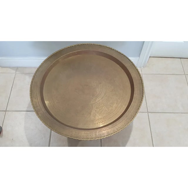 Twenties brass decorative tray folding hand-carved coffee table. Perfect little party table to bring out with extra...