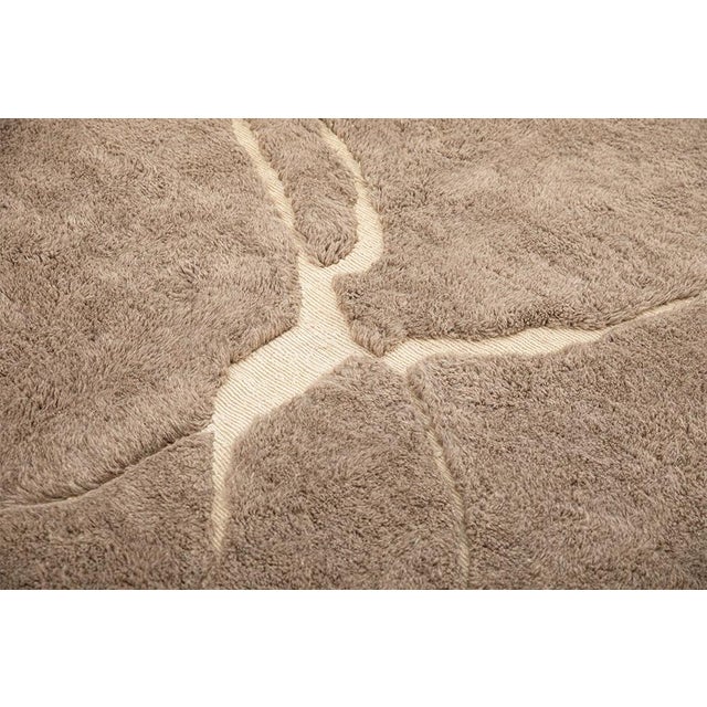 Contemporary hand-knotted wool rug in Light Taupe and Ivory, featuring an abstract pattern of intersecting lines and...