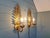 Pair of gold-tone metal wall sconces with floral decoration, Hollywood Regency style, made in Italy in the 1970s....