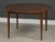 A mid century modern walnut round dining table with two 19.625” leaves that fully extend the table to 86.25” when...