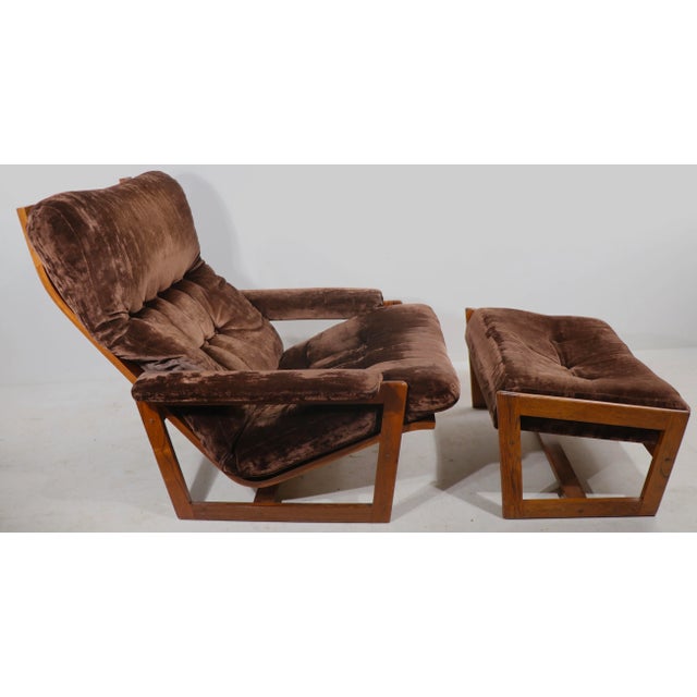 Architectural Mid Century lounge chair and ottoman, having an exposed rosewood frame with loose upholstered cushions....