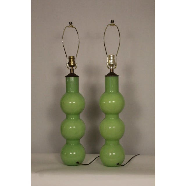 A pair of sculptural Murano glass table lamps. Hand blown stacked spheres. Vibrant chartreuse in color. Tall and sleek....