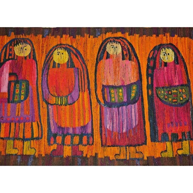 This vibrant mid-century hand-woven tapestry captures a charming folkloric scene of four schoolgirls dressed in...