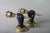 Matching pair of Art Deco wall sconces from the 1930s, each formed as a fist holding a torch, in solid brass with a dark...