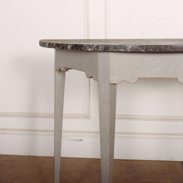 Small 19th century English console table with a brown and grey flecked marble top. 1900. This piece is designed in the...