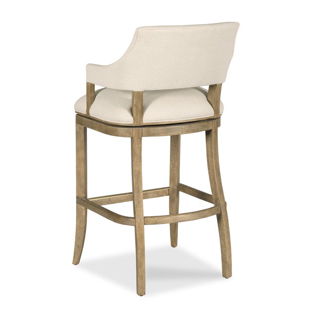 A curved upholstered back with descending curved arms over an upholstered seat elevated by tapering saber legs. Materials:...