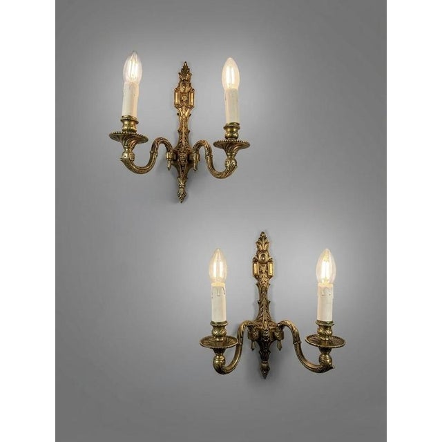 Beautiful pair of antique French wall lights. These bronze double-fitting sconces feature lovely foliage and scroll detail...