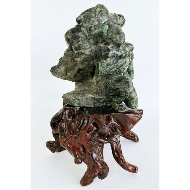 Asian Carved Figurative Precious Stone Sculpture on Root Stand Offered for sale is a hand-carved green mineral sculpture...