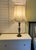 Elegant table lamps constructed with a green malachite and brass base. The lamp have tall, cream-colored fabric shades...