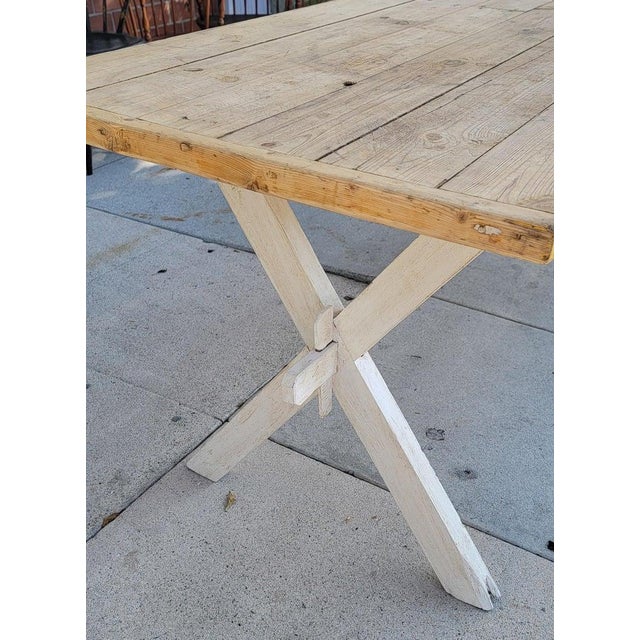 19Thc Sawbuck table with a natural scrub top that is two inch plank top.The base is a white painted base in a sawbuck...