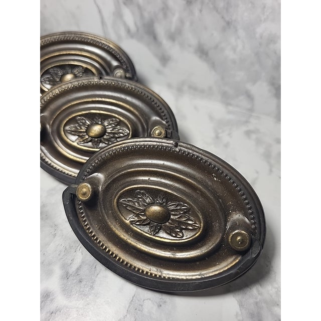 3 Vintage detailed brass cabinet pulls features a Federal style design with a rosette. Made of brass and originating from...
