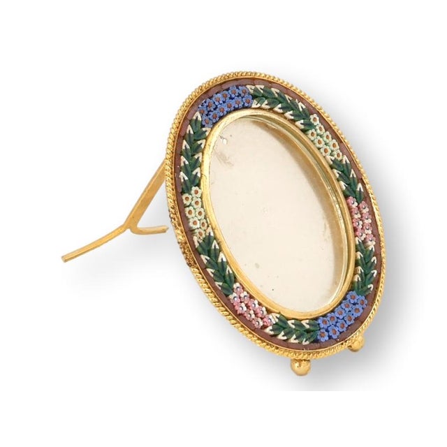 A luminous Italian micromosaic picture frame, hand-set with jewel-toned glass tesserae forming a floral garland around a...